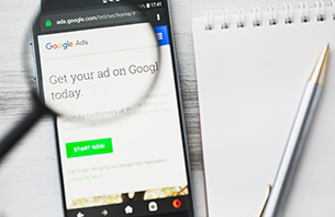 Mobile browser that says get ad on google ads today next to notepad and pen